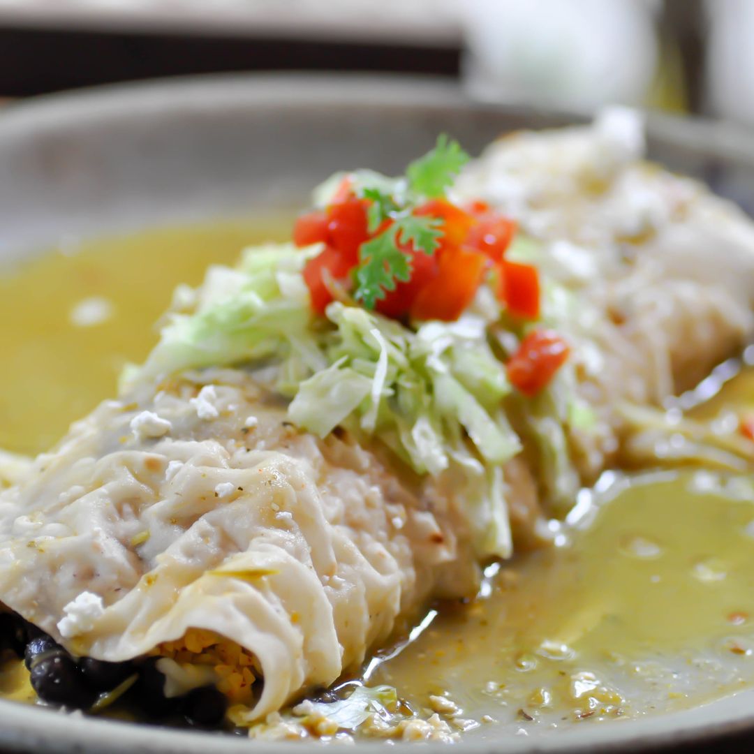 A burrito smothered in our signature green chili sauce texmex style